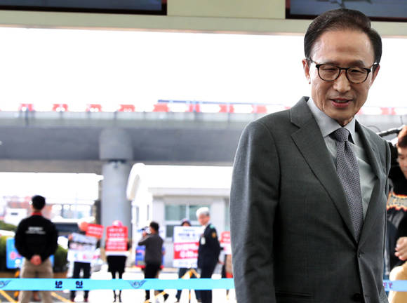 이명박 전 대통령이 12일 오전 인천국제공항을 통해 중동으로 출국하고 있다. 그 뒤로 이 전 대통령의 구속수사를 촉구하는 시민단체 회원들이 손팻말을 들고 시위를 하고 있다. 이 전 대통령은 이날 "지난 6개월 적폐청산이라는 명목으로 이뤄지는 것을 보면서 이것이 과연 개혁이냐, 감정풀이냐, 정치 보복이냐하는 의심이 들기 시작했다"고 밝혔다. 이 전 대통령은 바레인 주재 외교사절 등 고위공직자들을 대상으로 강연을 할 예정이다. ⓒ 뉴스1