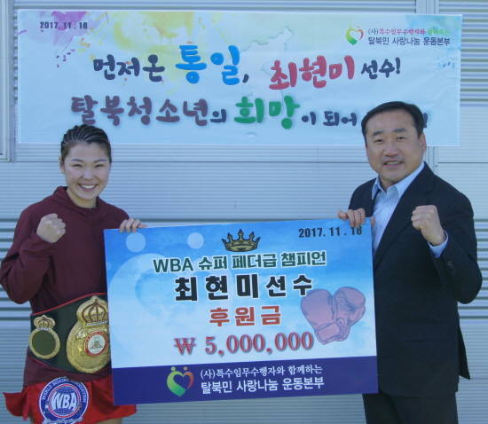 탈북민사랑나눔운동본부 김치곤 이사장이 지난 18일 타이틀 5차 방어에 성공한 최현미 선수에게 후원금을 전달하고 있다. ⓒ 특수임무수행자와 함께하는 탈북민사랑나눔운동본부