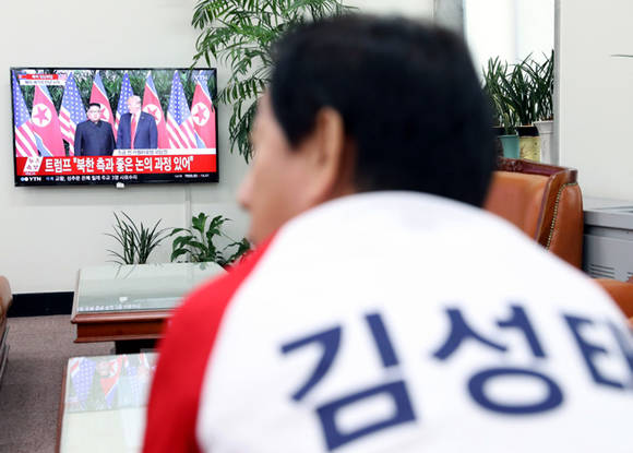 김성태 자유한국당 원내대표(중앙선대위 공동위원장)이 12일 오전 서울 여의도 국회 원내대표실에서 김정은 북한 국무위원장과 도널드 트럼프 미국 대통령의 북미정상회담 TV 생중계를 틀어놓고 기자회견문을 매만지고 있다. ⓒ 뉴스1