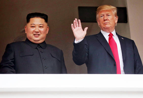 김정은 북한 국무위원장과 도널드 트럼프 미국 대통령이 12일 싱가포르 센토사 섬 카펠라호텔에서 취재진을 향해 인사하고 있다. (싱가포르통신정보부 제공) ⓒ 뉴스1