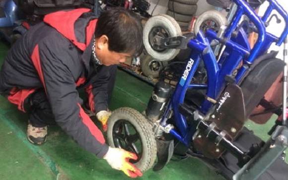 관계자들이 장애인 휠체어를 고치고 있는 모습이에요. ⓒ 구리시