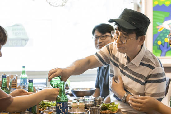 유시민 보해 사외이사가 신간 '역사의 역사' 캠페인 활동 후 스태프들과 천년애를 마시고 있다. ⓒ 보해양조