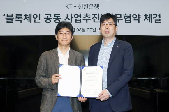 지난 7일 서울 중구 세종대로 소재 KT사옥에서 진행된 업무협약식에서 신한은행 디지털전략본부 장현기 본부장(사진 우측)과 KT 김학준 상무(사진 좌측)가 기념촬영을 하고 있다. ⓒ 신한은행