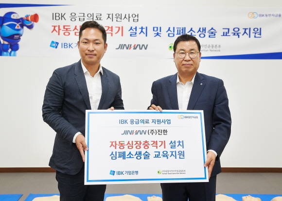 20일 경기도 군포시 소재 주식회사 진한 사업장에서 자동심장충격기 설치와 응급의료 교육을 마치고 김창호 기업은행 소비자브랜드그룹 부행장(오른쪽)과 배성환 주식회사 진한 이사가 기념촬영을 하고 있다. ⓒ IBK기업은행