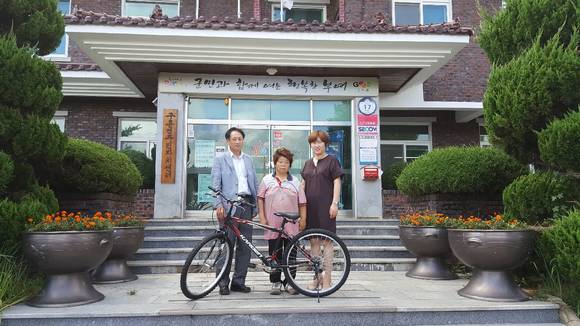 강진훤 이장이 경품으로 받은 자전거를 이웃에게 전달 기탁 후 기념촬영을 하고 있다. ⓒ 부여군