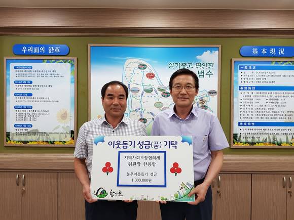 한용항 법수면 지역사회보장협의체 위원장이 이웃돕기 성금 100만원을 기탁하고 있다. ⓒ 함안군청