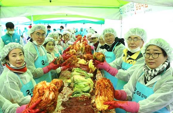 조영은 사회복지국장과 임현호 전무(우에서 2, 3번째), 강정범 상무(좌에서 두번째)가 관계자들과 김장을 하며 기념촬영을 하고 있다. ⓒ GS칼텍스