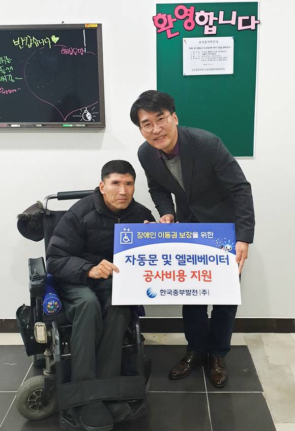 한국중부발전 김신형 기획본부장(오른쪽)이 충남중증장애인 자립생활협회에 '자동문 및 엘리베이터 공사비용'을 기부를 하고 있다. ⓒ 중부발전
