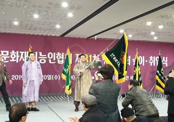 이광복 신임이사장(가운데)이 정문길 전 이사장으로부터 협회깃발을 전달받아 흔들고 있다. ⓒ 프라임경제