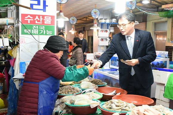 장충남 남해군수가 전통시장에서 지역화폐 화전으로 수산물을 구매하고 있다. ⓒ 남해군