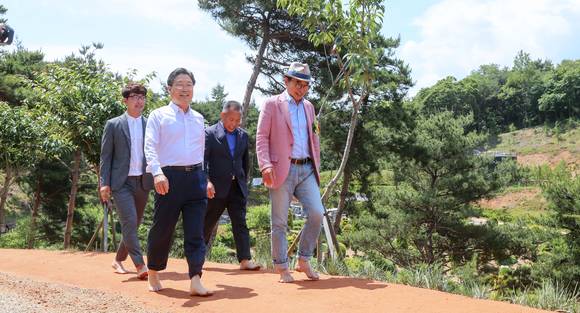 삼선산 수목원 황톳길 개통식 후 김홍장 시장과 관계자들이 걷고 있는 모습. ⓒ 당진시