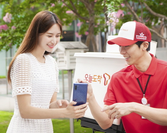 SK텔레콤 홍보모델들이 '갤럭시노트10플러스 아우라 블루' 제품과 공식 온라인몰 배송 서비스인 '오늘도착'을 소개하고 있다. ⓒ SK텔레콤