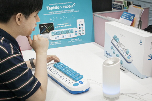 한 남성이 SK텔레콤과 오파테크가 공동 개발한 '스마트 점자학습 시스템'을 시연해보고 있다. ⓒ SK텔레콤