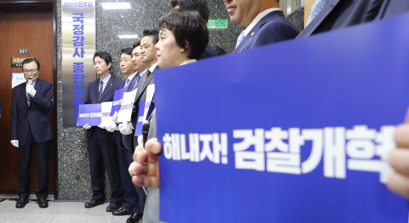 이해찬 대표가 30일 최고위원회 직후 진행된 국정감사종합상황실 현판식에서 발언하고 있다. 한 민주당 의원이 '해내자! 검찰개혁'이라고 적힌 종이를 들고 있다. ⓒ 연합뉴스