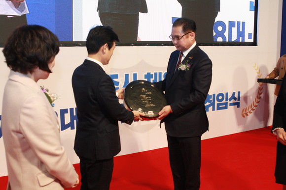 김택세 신임회장이 조규일 이임회장에게 체육발전의 공로를 새긴 징을 전달하고 있다. = 강경우 기자