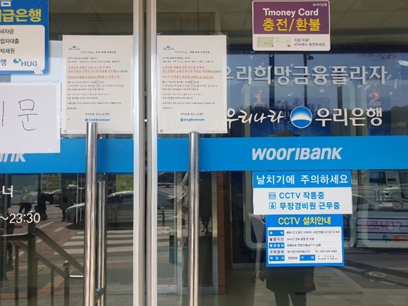 지난 18일 우리은행 입구 앞에는 신종 코로나바이러스 감염증(코로나19)로 안내문이 붙여있다. = 설소영 기자.