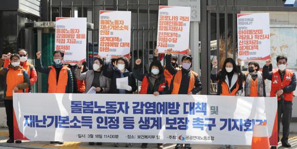 공공연대노동조합 관계자들이 18일 정부세종청사 보건복지부 앞에서 돌봄노동자 코로나19 감염예방 대책 및 재난기본소득 지급 등을 촉구하는 기자회견을 열고 구호를 외치고 있다. ⓒ 연합뉴스