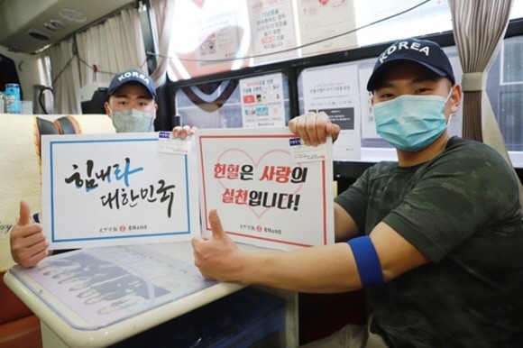 코로나19 확산 속 부족한 헌혈에 동참한 5사단 장병이 응원 메시지와 함께 기념 촬영하는 모습. ⓒ 연합뉴스