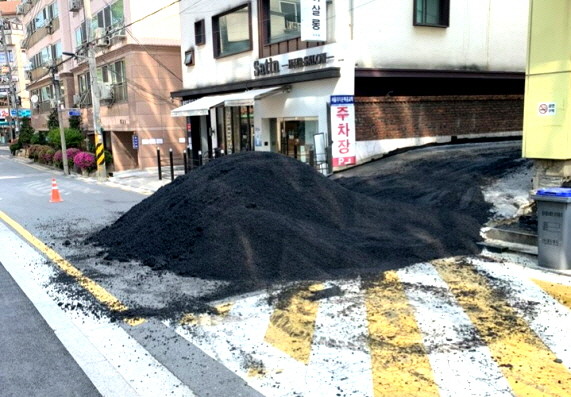 공사용 아스팔트 재료가 주차장에서 도로로 흘러내리고 있다. ⓒ 인근 주민