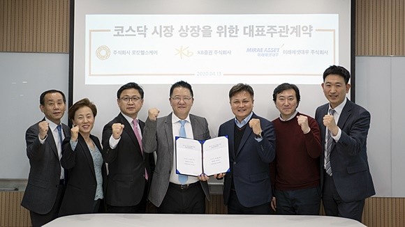 로킷헬스케어는 내년 코스닥시장 입성을 목표로 IPO 대표주관사 KB증권, 공동주관사 미래에셋대우를 선정해 상장 채비를 마쳤다. 유석환 로킷헬스케어 대표(왼쪽에서 네 번째)와 이상오 KB증권 이사(왼쪽에서 다섯 번째)를 비롯한 관계자들이 기념사진을 촬영하고 있다. ⓒ 로킷헬스케어