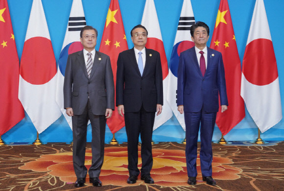 문재인 대통령과 아베 일본 총리, 리커창 중국 총리가 지난해 12월24일, 쓰촨성 청두 세기성 박람회장에서 한중일 비즈니스 서밋 시작 전 기념촬영을 하고 있다. Ⓒ 연합뉴스