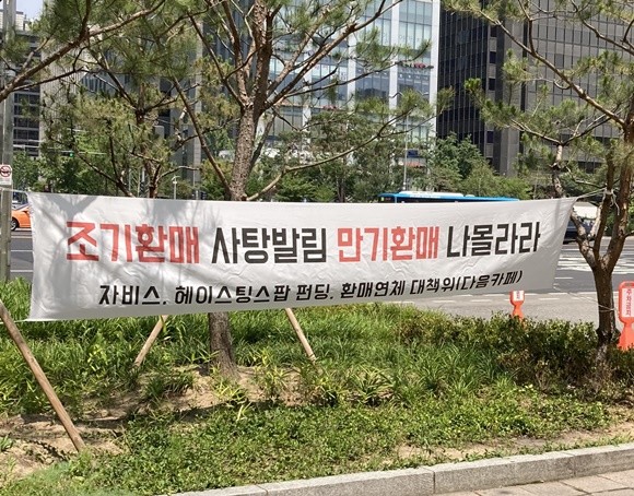 한국투자증권이 판매한 개인 간 거래(P2P) 대출업체 '팝펀딩' 연계 사모펀드 환매중단 사태에 투자자들이 불완전판매 등을 주장하며 집단 대응을 예고하고 나섰다. 사진은 한국투자증권 사옥 앞에 걸린 현수막. = 이지운 기자