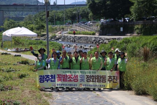광주도시철도공사 노사가 광주천변 꽃길 조성 작업을 벌인 후 기념촬영을 하고 있다. ⓒ 광주도시철도공사