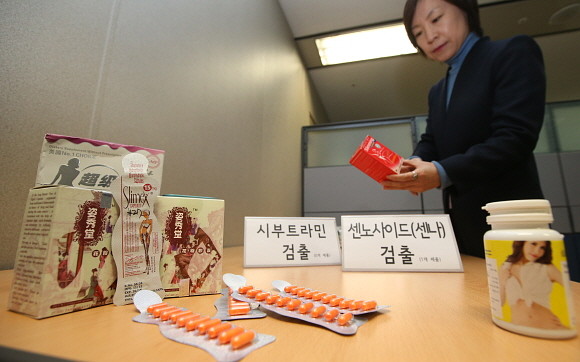 한국소비자원 관계자가 사용금지 의약품이 검출된 다이어트 식품을 살펴보고 있다. © 연합뉴스