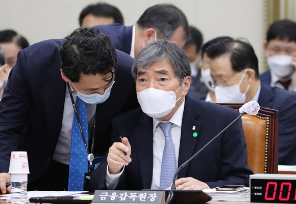 윤석헌 금감원장이 29일 오전 서울 여의도 국회에서 열린 정무위원회 전체회의에서 관계자로부터 보고를 받고 있다. ⓒ 연합뉴스