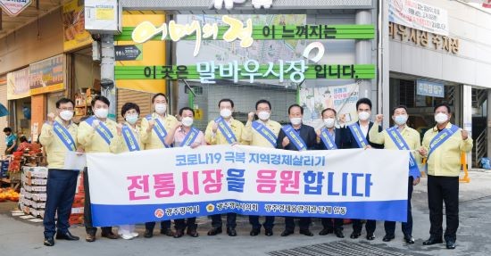 이용섭 광주광역시장이 14일 오후 북구 말바우시장을 방문해 김용집 광주광역시의회 의장, 문인 북구청장, 조석호·정순애 광주시의회 부의장, 이정환 광주시의회 산업건설위원장, 이경호 광주시의원, 경제 관련 단체장 등과 함께 전통시장 응원 퍼포먼스를 하고 있다. ⓒ 광주광역시