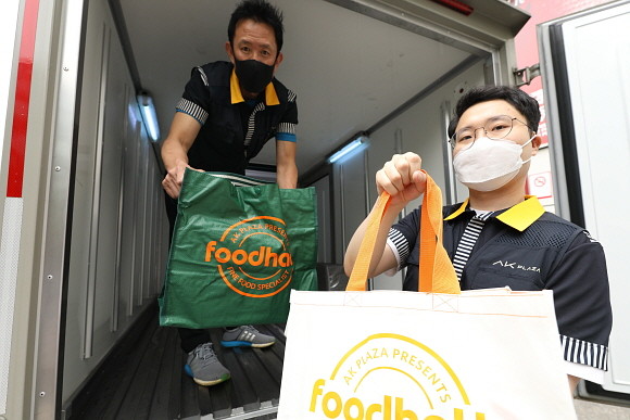 근거리배송 직원들이 살균된 장바구니를 꺼내보이고 있다. © AK플라자