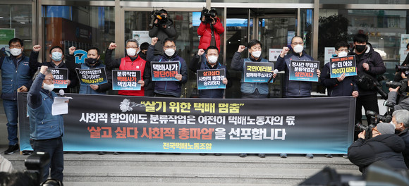 지난 27일 오후 서울 중구 한진택배 본사 앞에서 열린 전국택배노조 총파업 돌입 기자회견에서 참가자들이 구호를 외치고 있다. ⓒ 연합뉴스