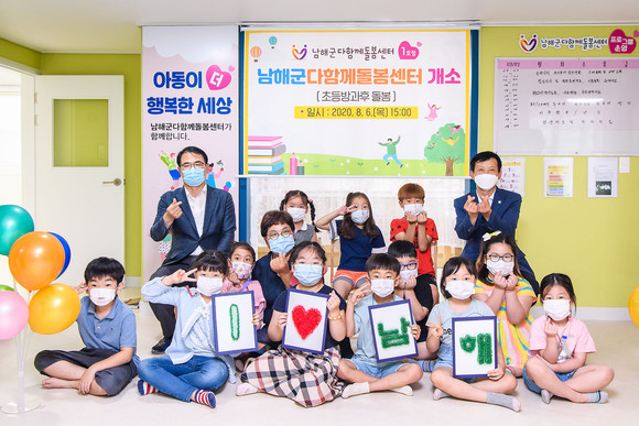 장충남 군수가 다함께 돌봄센터 개소식에서 아이들과 눈 높이를 같이 하고 있다. ⓒ 남해군