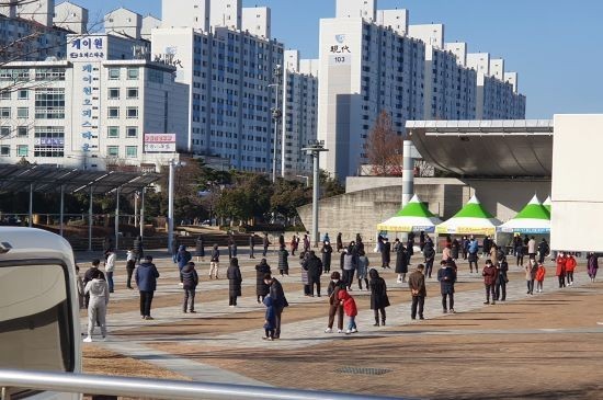 TCS국제학교에서 무더기 확진자가 나온 27일 오전 광주시청 광장에 마련된 코로나19 선별검사소에 시민들이 긴 줄을 서 대기하고 있다. ⓒ 프라임경제