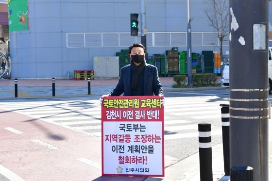 조현신 운영위원장이 진주혁신도시에서 교육센텨 김천시 이전을 결사 반대하는 피켓을 들고 있다. ⓒ 프라임경제