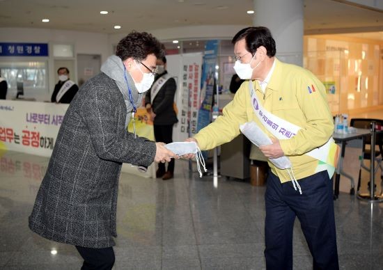이용섭 광주광역시장이 9일 오전 시청 1층 로비에서 출근하는 직원들에게 청렴 문구가 적힌 마우스패드를 전달하며 설 명절 공직자 청렴켐페인을 펼치고 있다. ⓒ 광주광역시