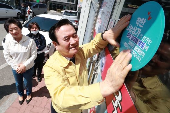 서춘수 함양군수가 착한 임대료 운동 홍보물을 부착하고 있다. ⓒ 함양군