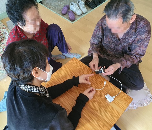 보건소 직원이 손목시계형 배회감지기를 설명하고 있다. ⓒ 함안군