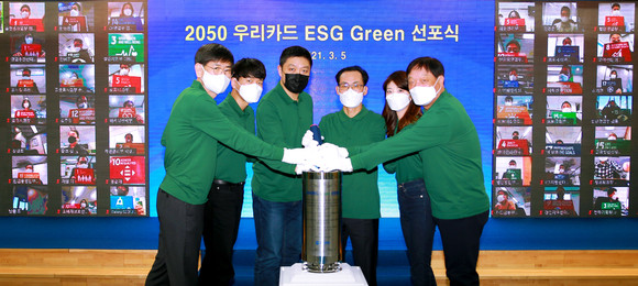우리카드 본사에서 열린 '2050 우리카드 ESG Green 선포식'에서 김정기 사장(왼쪽에서 네번째), 최현수 노조위원장(왼쪽에서 세번째), 이상우 상근감사위원(왼쪽 첫번째), 허정진 부사장(오른쪽 맨끝)과 임직원 대표 2명이 그린 선언문을 타임캡슐에 넣고 있다. ⓒ 우리카드