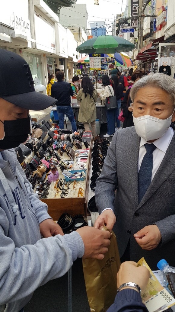 시장 유세 중 실제로 물건을 구매하고 애환을 들어보기도 하는 정규재 자유민주당 부산시장 후보. = 서경수 기자