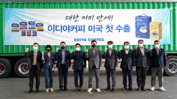 26일 이디야커피 문창기 회장(왼쪽에서 다섯 번째)을 비롯한 관계자들이 미국 수출용 제품을 담은 컨테이너 앞에서 기념촬영을 하고 있다. ⓒ 이디야커피
