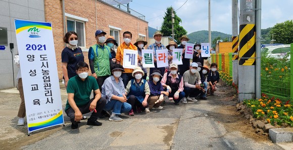 농업기술센터는 지난 24일 채송화 등 초화류 500본을 심는 '게릴라 가드닝' 행사를 진행 후 기념촬영을 하고 있다. ⓒ 계룡시