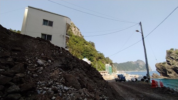 터널공사로 흘러내린 토사와 돌들이 건물 앞을 가로막고 있다. ⓒ 프라임경제
