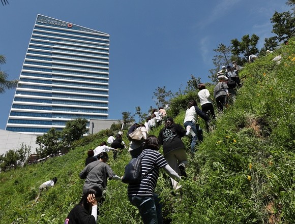 지난 23일, 원주시 건보공단 인근 집회 장소로 향하는 출입 통로가 경찰 차벽에 의해 막히자 언덕을 건너는 노조의 모습. ⓒ 연합뉴스
