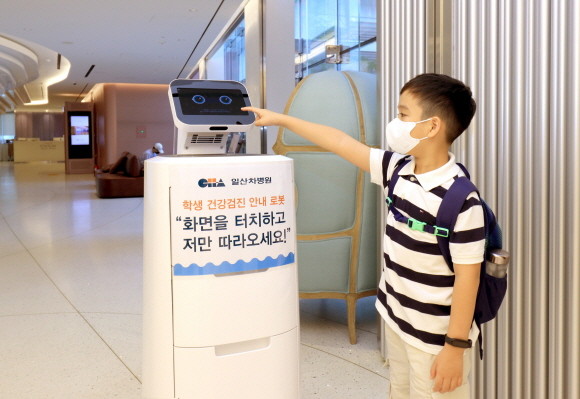 일산차병원에서 한 학생이 학생검진 안내를 받기 위해 학생검진도우미 안내 로봇 클로이를 터치하고 있다. © 차병원