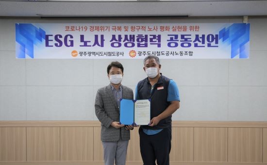 광주도시철도공사 윤진보 사장과 이정수 노동조합 위원장이 'ESG 노사 상생협력 공동선언문'에 합의하고 기념촬영을 하고 있다. ⓒ 광주도시철도공사