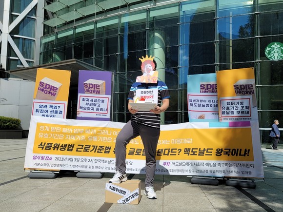 3일 종로타워 앞에서 대책위가 웃으면서 불량버거를 판매하는 맥도날드를 풍자하는 퍼포먼스를 펼치고 있다.=윤수현 기자