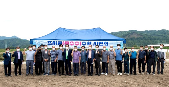 지난 6일 백운면 도곡리 일원에서 베일러와 랩핑기를 활용한 사료용 옥수수 수확 시연회를 개최 후 기념촬영을 하고 있다. ⓒ 제천시
