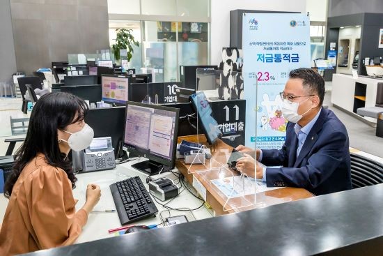 송종욱 광주은행장이 소액 적립으로 목돈 마련과 함께 백신 접종 고객에게 우대금리를 제공하는 '저금통적금'에 1호로 가입하고 있다. ⓒ 광주은행