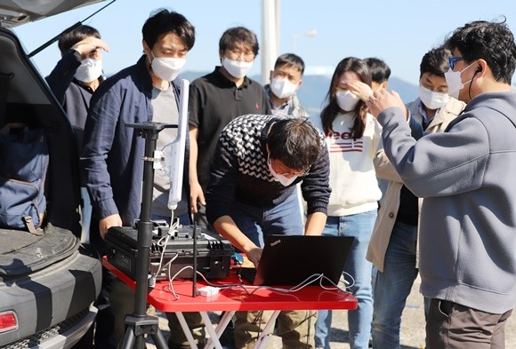지난 25일 순천만 화포해변에서 무인기를 이용한 해양 및 하천 모니터링 현장 실증 기술 시연회가 열린 가운데 관계자들이 원격 조종 장치를 보며 기체를 운용하고 있다. ⓒ 프라임경제